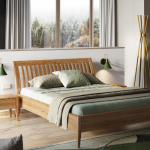 Drewniane łóżko w przestronnej, jasnej sypialni